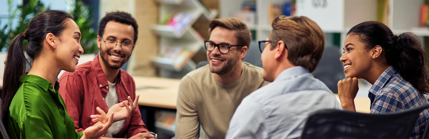 A group of diverse people sitting in a group talking enthusiastically with one another