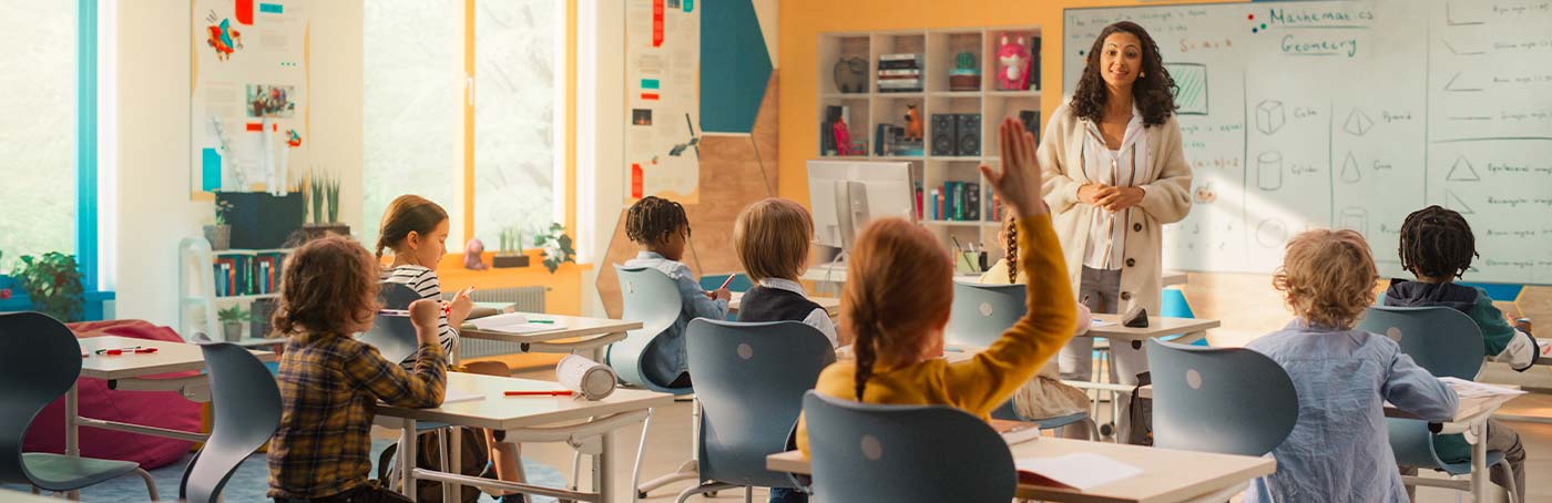 A classroom full of young children and a teacher at the whiteboard
