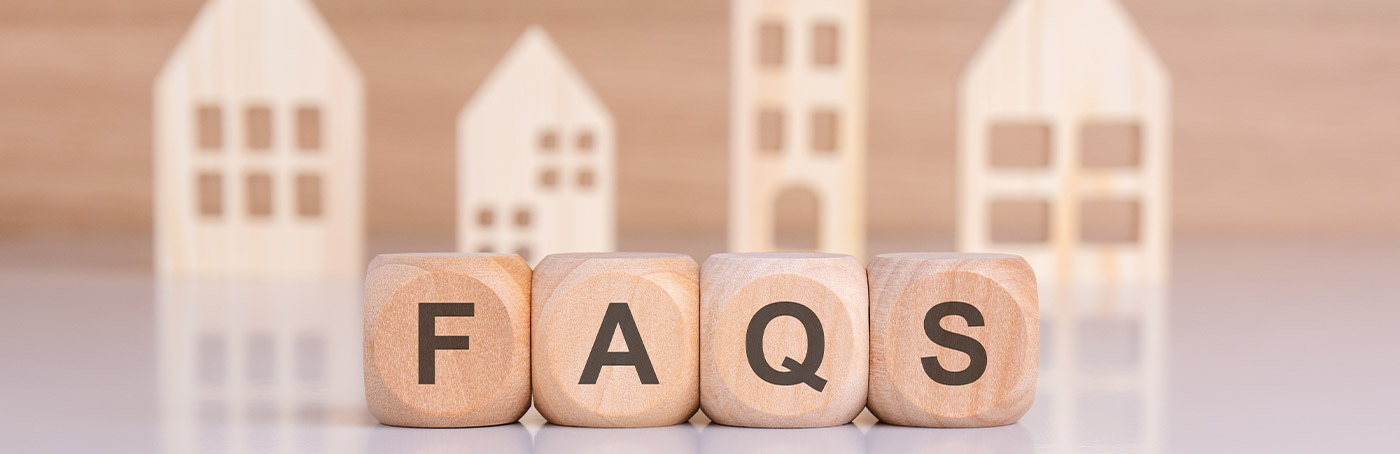 Wooden letters spelling out FAQs with images of different housing silhouettes in the background